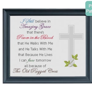 Può includere: Un ricamo a punto croce incorniciato con una croce grigia e foglie verdi. Il testo recita "I still believe in Amazing Grace that there's Power in the Blood that He Walks With Me and He Talks With Me that Because He Lives I can face tomorrow all because of The Old Rugged Cross".