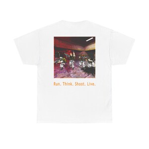 May include: A white t-shirt featuring a square graphic on the back depicting a group of soldiers in a dark, red-lit interior setting. Below the graphic, the orange text reads: Run. Think. Shoot. Live. The shirt has short sleeves and a crew neck.