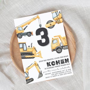 Puede incluir: Una invitación de cumpleaños con un gran número 3 negro rodeado de ilustraciones de vehículos de construcción amarillos y grises. La invitación incluye el texto "STOP THE TRAFFIC, CLOSE THE ROAD" y detalles del evento.