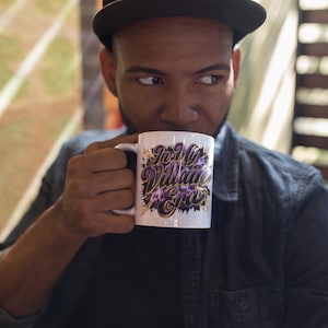 May include: White ceramic mug featuring the text "In My Villain Era" in purple and gold lettering. The mug has a black handle and a black and purple design. The mug is held by a person.