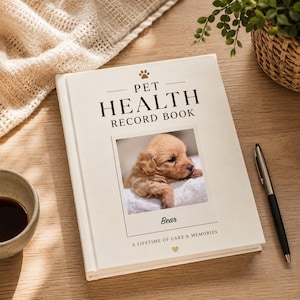 Peut inclure: Un carnet de santé pour animal de compagnie à couverture rigide couleur crème, orné d'une photo centrale d'un chiot brun clair. Le texte indique PET HEALTH RECORD BOOK, le nom Bear, et A LIFETIME OF CARE & MEMORIES, avec une patte et un cœur.