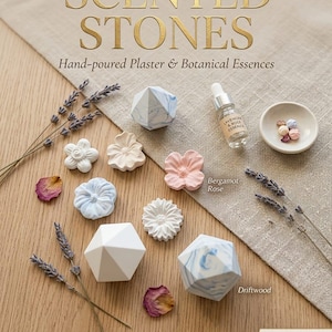 May include: An assortment of scented plaster stones in various shapes and colors, including floral and geometric designs. The image features a bottle of essential oil, dried lavender, and the text "SCENTED STONES".