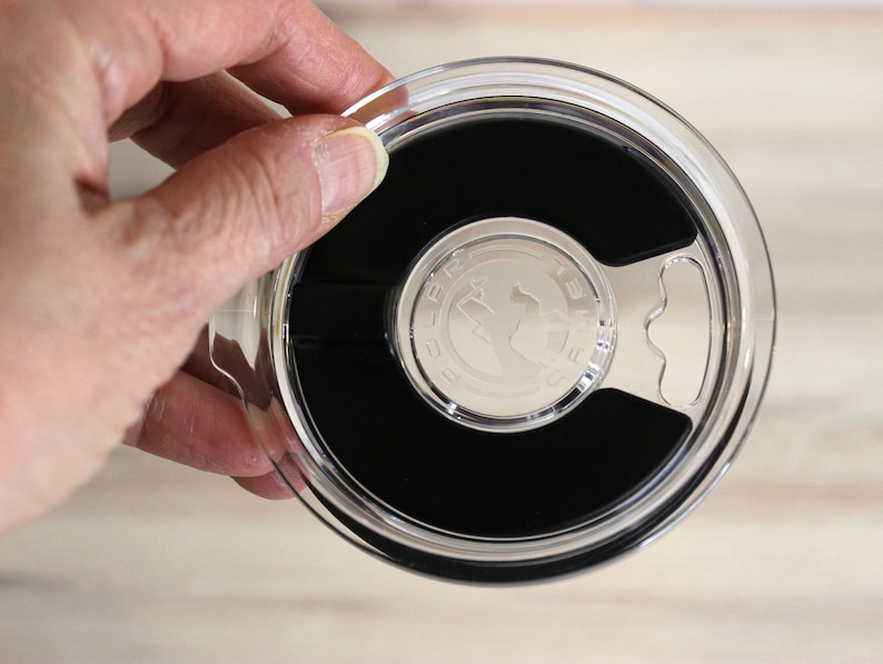 May include: Clear plastic lid with a black rubber seal and a silver handle. The lid has the words "BULA" and "12 oz" printed on it.