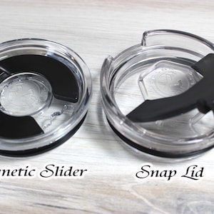 May include: Two clear plastic lids for a travel mug. The lid on the left is a magnetic slider lid. The lid on the right is a snap lid.