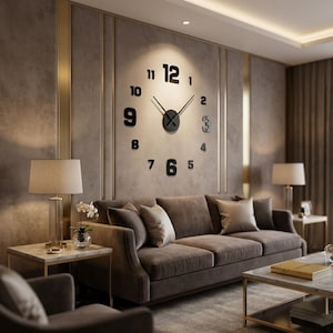 Könnte beinhalten: Eine große Wanduhr mit einzelnen schwarzen Klebezahlen, die in einem kreisförmigen Muster angeordnet sind. Die Uhr hat ein zentrales schwarzes, kreisförmiges Uhrwerk mit zwei langen, dünnen schwarzen Zeigern. Die Zahlen sind fett.