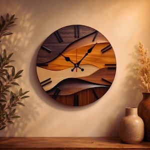 May include: A round wooden wall clock with a layered design. The clock face features a wave-like pattern in shades of brown, tan, and light wood. Black hands and hour markers contrast the natural wood tones. The clock is mounted on a beige wall.