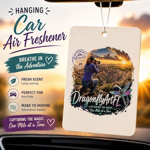 Puede incluir: Ambientador de coche colgante con imagen de fot&oacute;grafa al atardecer. El dise&ntilde;o incluye el texto "Breathe in the Adventure" y "DragonflyArtFL". Promete un aroma fresco y duradero, ideal para cualquier viaje.