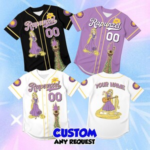 May include: Three baseball jerseys in black, purple, and white, each featuring a Rapunzel graphic, the text Rapunzel, the number 00, and a tower illustration. One white jersey back displays the text YOUR NAME and Rapunzel playing a guitar.