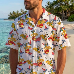 Può includere: Una camicia bianca a maniche corte con bottoni, caratterizzata da una stampa all-over del personaggio dei cartoni animati Pluto che gioca con un pallone da spiaggia rosso e giallo, intervallata da piccole barche a vela rosse e ancore blu.