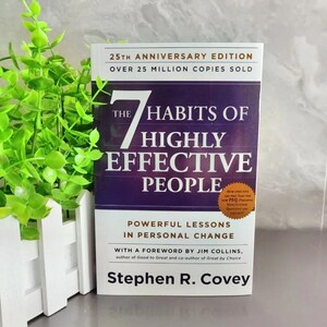 Puede incluir: El libro 25th Anniversary Edition titulado The 7 Habits of Highly Effective People de Stephen R. Covey. La portada es morada y blanca con el texto Powerful Lessons in Personal Change y una insignia circular dorada que dice New PEQ.