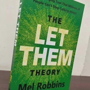 May include: A hardcover book titled "THE LET THEM THEORY" by Mel Robbins. The book has a green cover with white and yellow text. The cover also includes the text "A Life-Changing Tool That Millions of People Can't Stop Talking About."