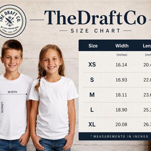 Puede incluir: Una tabla de tallas de camisetas blancas con medidas en pulgadas. La tabla incluye tallas XS a XL, con las medidas de ancho y largo correspondientes. Dos ni&ntilde;os modelan las camisetas. La marca "The Draft Co" se muestra en la parte superior.