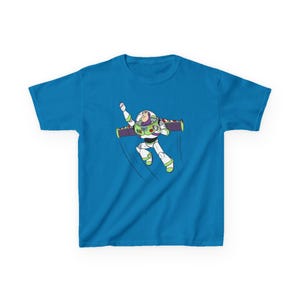 Puede incluir: Camiseta azul turquesa con una ilustraci&oacute;n de dibujos animados de Buzz Lightyear en vuelo. El personaje, con su traje espacial, tiene un brazo levantado y un jetpack, con una l&iacute;nea din&aacute;mica que indica movimiento.