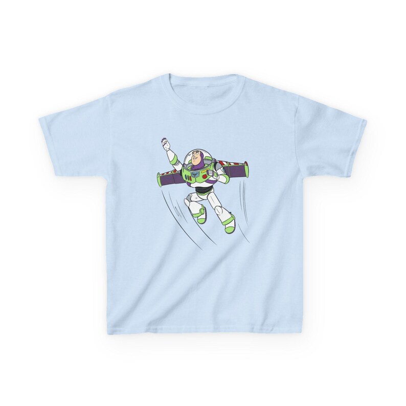 Puede incluir: Camiseta azul claro con una ilustraci&oacute;n de dibujos animados de Buzz Lightyear en pleno vuelo. El personaje lleva su traje de guardabosques espacial, con detalles verdes, blancos, morados y rojos. La camiseta es de tejido suave.