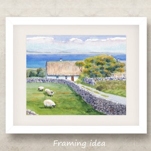 May include: Watercolor painting of a rural landscape with a white cottage, thatched roof, and stone wall. Sheep graze in a green field. The background features a blue sea and sky. The painting is framed in a white border.