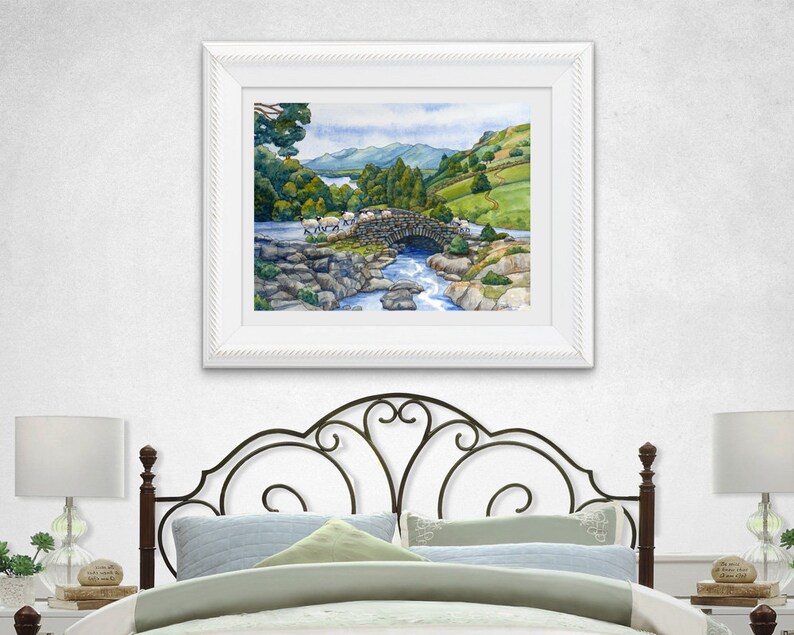 Pode incluir: Uma pintura em aquarela de uma ponte de pedra sobre um rio com ovelhas cruzando-a. A ponte &eacute; cercada por &aacute;rvores verdes e colinas. O c&eacute;u &eacute; azul com nuvens brancas.