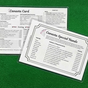 May include: Two rectangular, laminated reference cards for the game of Canasta. One card displays Canasta Card rules, scoring, and meld requirements. The other card lists Canasta Special Hands, patterns, and point values in black text on white.