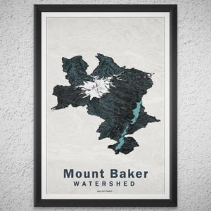 Könnte beinhalten: Gerahmter Druck des Mount Baker Watershed. Die Karte zeigt ein dunkelblaugrünes topografisches Design mit einem weißen Berggipfel und einem hellblauen Fluss. Die Worte "Mount Baker Watershed" sind in Dunkelblau gedruckt.