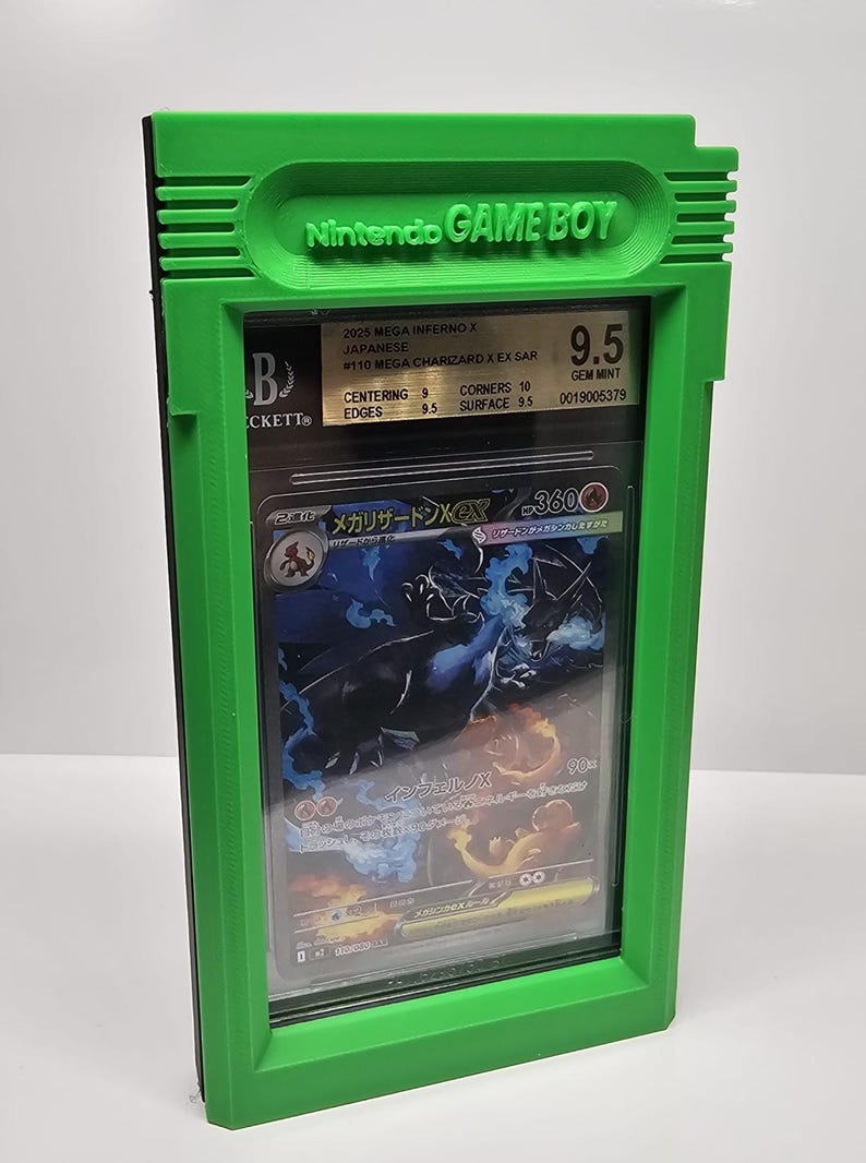 Op de afbeelding: Een groene plastic behuizing die lijkt op een Game Boy, met daarin een beoordeelde Pok&eacute;mon-kaart. De kaart heeft een Charizard-illustratie en is beoordeeld met 9,5. De behuizing heeft het Nintendo Game Boy-logo.