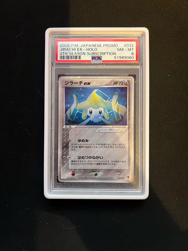 May include: A graded Pok&eacute;mon card featuring Jirachi EX-Holo from the 2006 P.M. Japanese Promo set. The card is encased in a protective holder with the text "Jirachi ex" and "HP70" visible. The card has Japanese text.