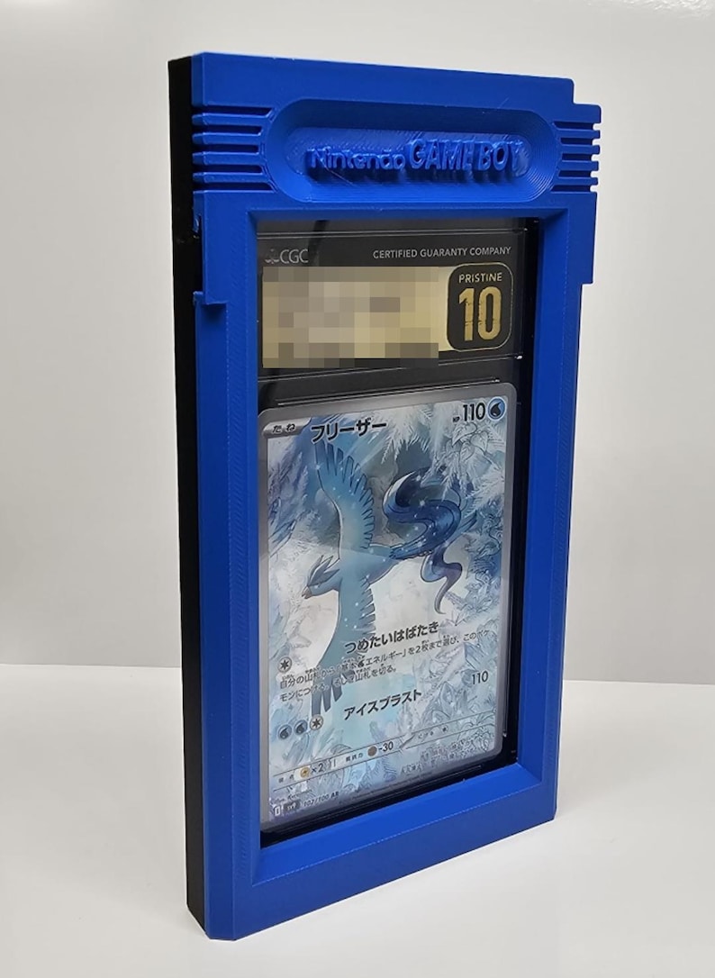 Op de afbeelding: Een blauwe Game Boy-stijl display case met een beoordeelde trading card. De case heeft de tekst "Nintendo GAME BOY". De kaart is beoordeeld met "Pristine 10" door CGC en heeft een illustratie.
