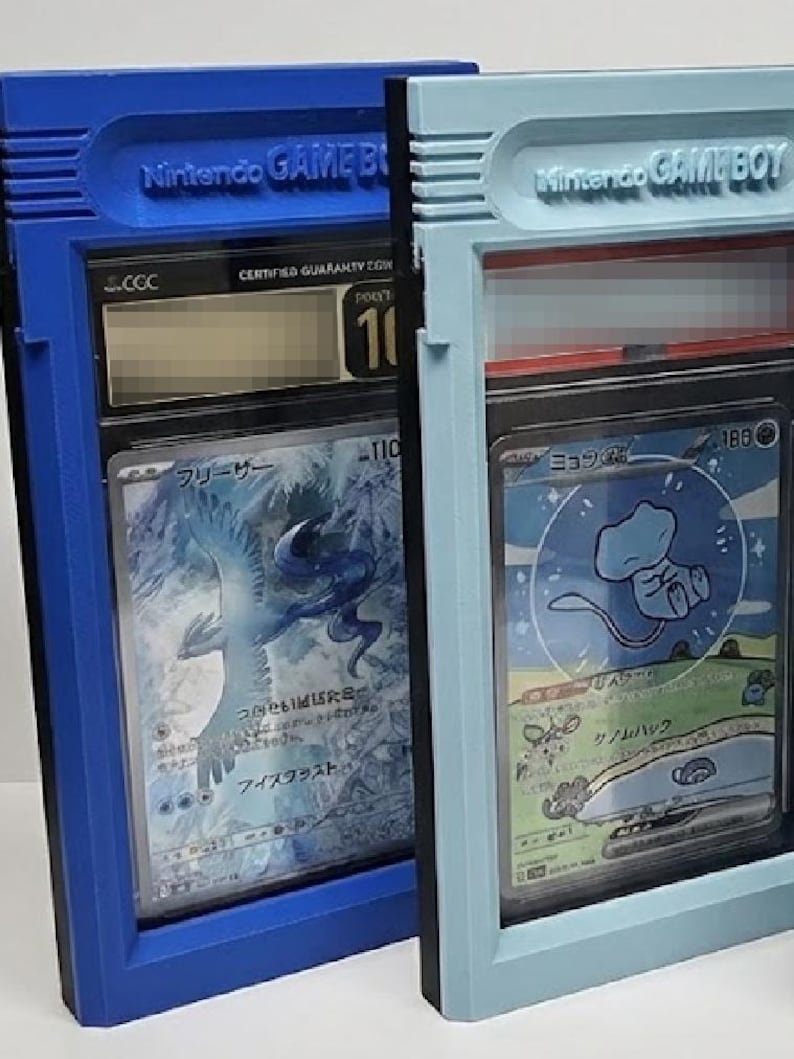 Op de afbeelding: Twee beschermende hoesjes voor verzamelkaarten, ontworpen om op Nintendo Game Boy-cartridges te lijken. E&eacute;n is blauw, de andere lichtblauw. Elke hoes bevat een kaart met Japanse tekst en illustraties. De hoesjes hebben de tekst "Nintendo GAME BOY" erop.