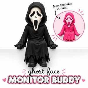 May include: A black Ghost Face figure with a white mask and hooded robe sitting on a ledge. Text reads: Also available in pink! ghost face MONITOR BUDDY. The figure has black gloves and boots, with a circular inset showing a pink version of the same figure.