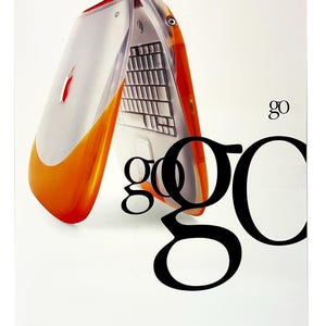 May include: An orange and white laptop with a transparent cover, the Apple logo is visible. The word "go" is in a large, bold font. The poster is for Macworld New York 99.