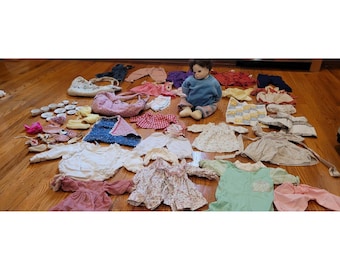 Gran lote de ropa para muñecas vintage variada con muñeca de ojos realistas y pesada de 20 pulgadas.