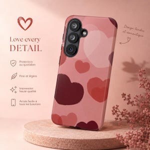 Peut inclure: Une coque de téléphone rose avec un motif de cœurs. La coque présente un motif de cœurs superposés dans des tons de rose et de bordeaux. Le texte sur la coque indique "Love every DETAIL" et "Design tendre et romantique".