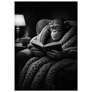May include: A black and white photograph of a chimpanzee wearing glasses, sitting in an armchair whilst wrapped in a thick, chunky knit blanket. The chimpanzee is holding an open book, and a steaming mug sits on a side table next to a lamp.