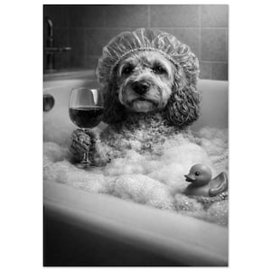 May include: Black and white image of a dog in a bathtub filled with bubbles, wearing a shower cap and holding a glass of red wine. A rubber duck floats nearby. The dog is the focal point of the image.