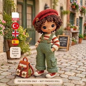 Peut inclure: Poupée au crochet faite à la main, portant un béret rouge, une chemise rayée et une salopette verte. La poupée a un petit sac à dos et des chaussures rouges. Le texte de l'image indique "PDF PATTERN ONLY - NOT FINISHED DOLL."