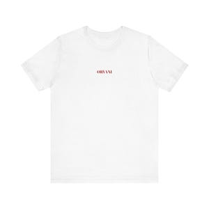 Może przedstawiać: Biały t-shirt z krótkim rękawem, okrągłym dekoltem i napisem ORVANI wydrukowanym ciemnoczerwoną czcionką szeryfową na środku klatki piersiowej. Odzież ma standardowy krój, krótkie rękawy i proste wykończenie u dołu.
