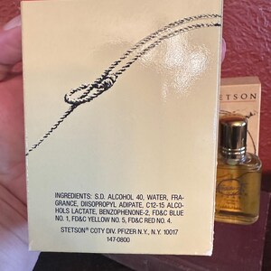 May include: A vintage Stetson cologne box and bottle. The box is beige with a rope design and text that includes ingredients and the Stetson brand. The bottle is small, clear, and has a gold cap. The text on the box reads "Stetson".