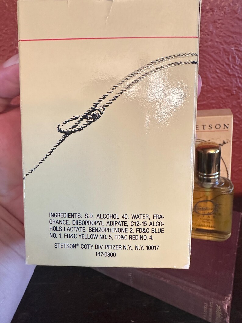 May include: A vintage Stetson cologne box and bottle. The box is beige with a rope design and text that includes ingredients and the Stetson brand. The bottle is small, clear, and has a gold cap. The text on the box reads "Stetson".