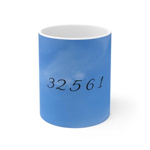 May include: White ceramic mug with a blue sky and cloud design. The number "32561" is printed in black on the mug. The mug has a white interior and a glossy finish.