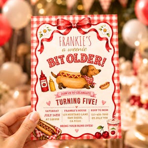 Puede incluir: Una invitación rectangular con borde de cuadros rojos y blancos, que presenta un perro salchicha disfrazado de perrito caliente, un lazo rojo y el texto Frankie's a weenie bit older! Turning five! con detalles del evento el 14 de julio.
