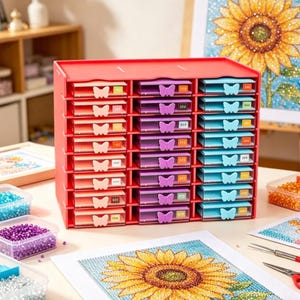 May include: A red plastic craft organizer with multiple drawers in shades of pink, purple, and blue. Each drawer has a butterfly-shaped handle. The organizer is designed for storing small craft supplies, such as beads.