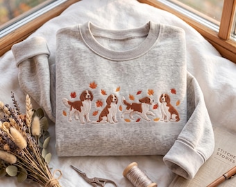 Sudadera bordada con diseño de perro Welsh Springer Spaniel y cuello redondo con estampado de hojas de otoño.