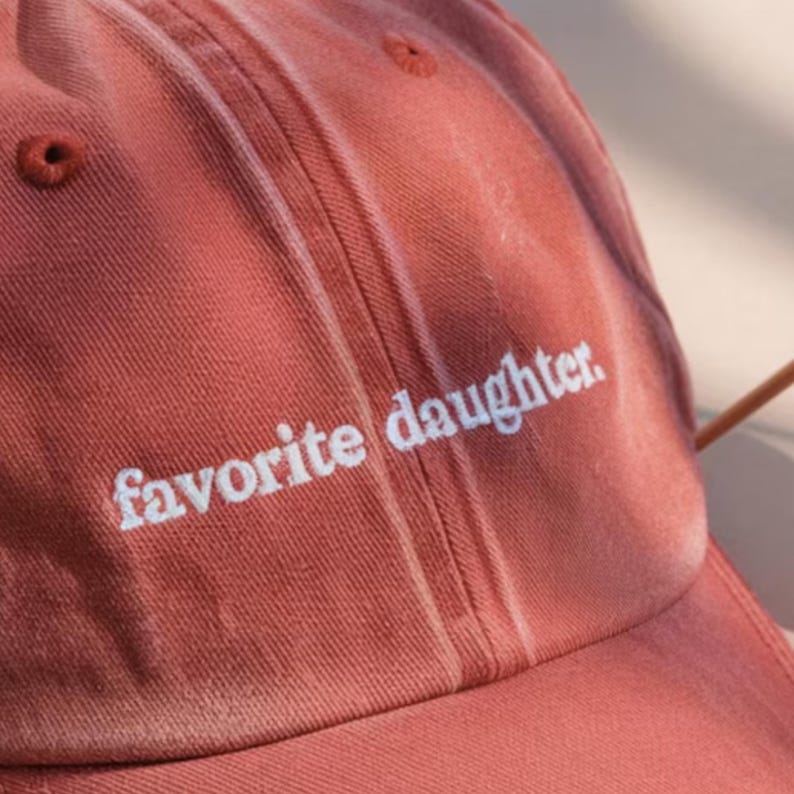 K&ouml;nnte beinhalten: Staubrosa Baseballkappe mit dem wei&szlig;en Schriftzug "favorite daughter". Die Kappe hat einen gebogenen Schirm und ein klassisches Sechs-Panel-Design.