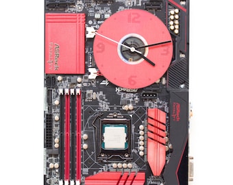 Wandklok gemaakt van een donkerbruine printplaat met een rode wijzerplaat, klaar voor verzending