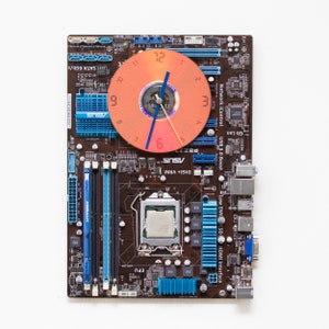 Wall clock made of dark brown circuit board with bright blue details, ready to ship