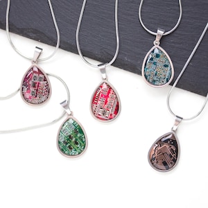 May include: Five teardrop-shaped pendant necklaces with silver chains. Each pendant features a circuit board design in various colors: red, green, and black. The pendants are set in silver-colored metal.