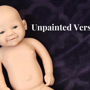 May include: A lifelike, unpainted baby doll with a smiling expression. The doll has a smooth, pale skin tone and is lying on a dark purple surface. The text "Unpainted Version" is displayed in white.