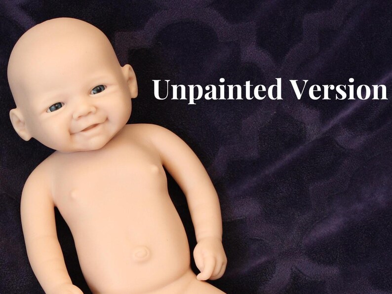 May include: A lifelike, unpainted baby doll with a smiling expression. The doll has a smooth, pale skin tone and is lying on a dark purple surface. The text "Unpainted Version" is displayed in white.
