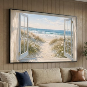 May include: A rectangular wall art print featuring an open window view of a sandy beach with dunes, white flowers, and blue ocean waves under a bright sky. The scene is framed by white window panes and sheer curtains on both sides of the print.