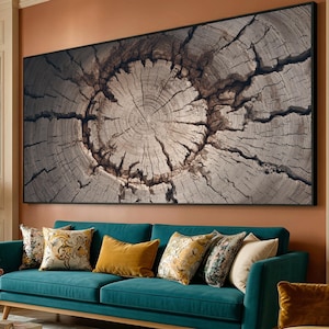 May include: Large framed artwork featuring a detailed close-up of a tree trunk cross-section. The wood grain is visible, with concentric rings and deep cracks. The color palette is primarily neutral, with shades of gray and brown.