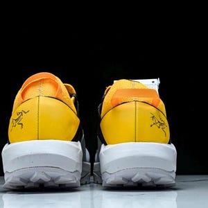Puede incluir: Par de zapatillas deportivas amarillas y negras con suelas blancas. Las zapatillas tienen un contrafuerte de tal&oacute;n amarillo con un gr&aacute;fico negro y una suela blanca con un patr&oacute;n texturizado. Las partes superiores son una combinaci&oacute;n de amarillo y negro.
