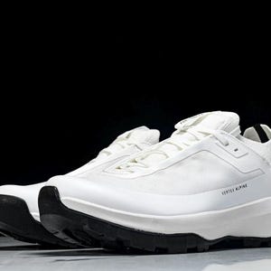 Puede incluir: Par de zapatillas deportivas blancas con suelas negras. Las zapatillas tienen un dise&ntilde;o aerodin&aacute;mico con el texto "VERTEX ALPINE" impreso en el lateral. Las zapatillas est&aacute;n sobre un fondo oscuro.